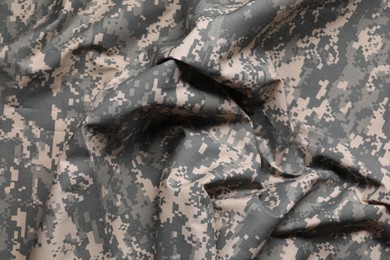 Photo of Texture of crumpled camouflage fabric as background, top view