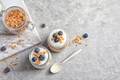Photo of Jars with yogurt, berries and granola on  table, top view