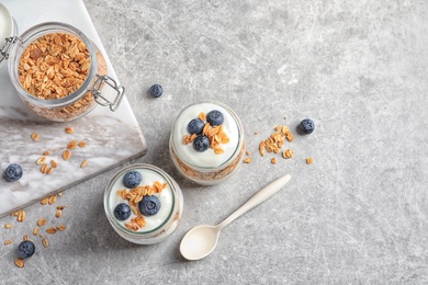 Jars with yogurt, berries and granola on  table, top view