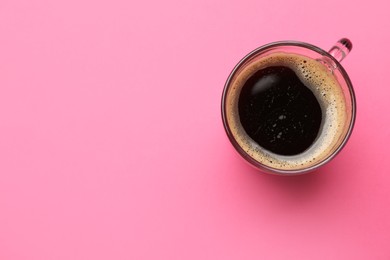 Photo of Fresh coffee in cup on pink background, top view. Space for text