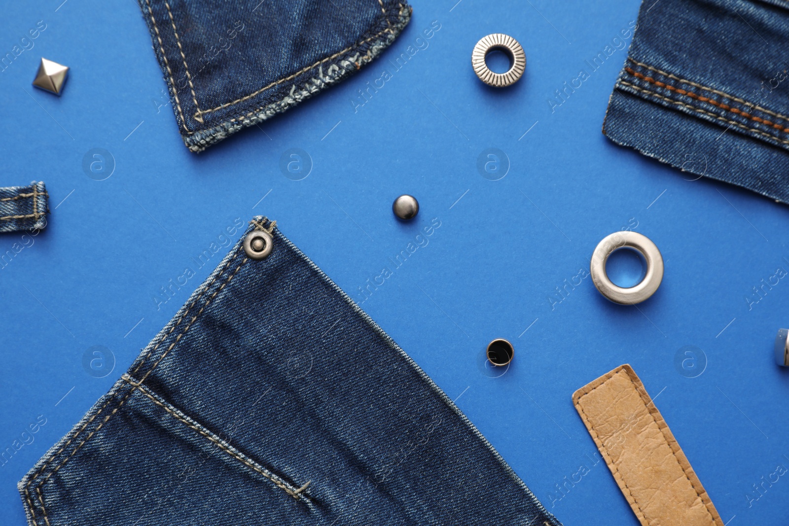 Photo of Flat lay composition with garment accessories and cutting details for jeans on blue background