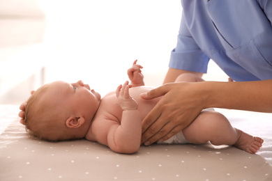 Doctor examining cute baby in clinic, closeup. Health care