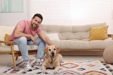 Photo of Man with adorable Labrador Retriever dog at home. Lovely pet