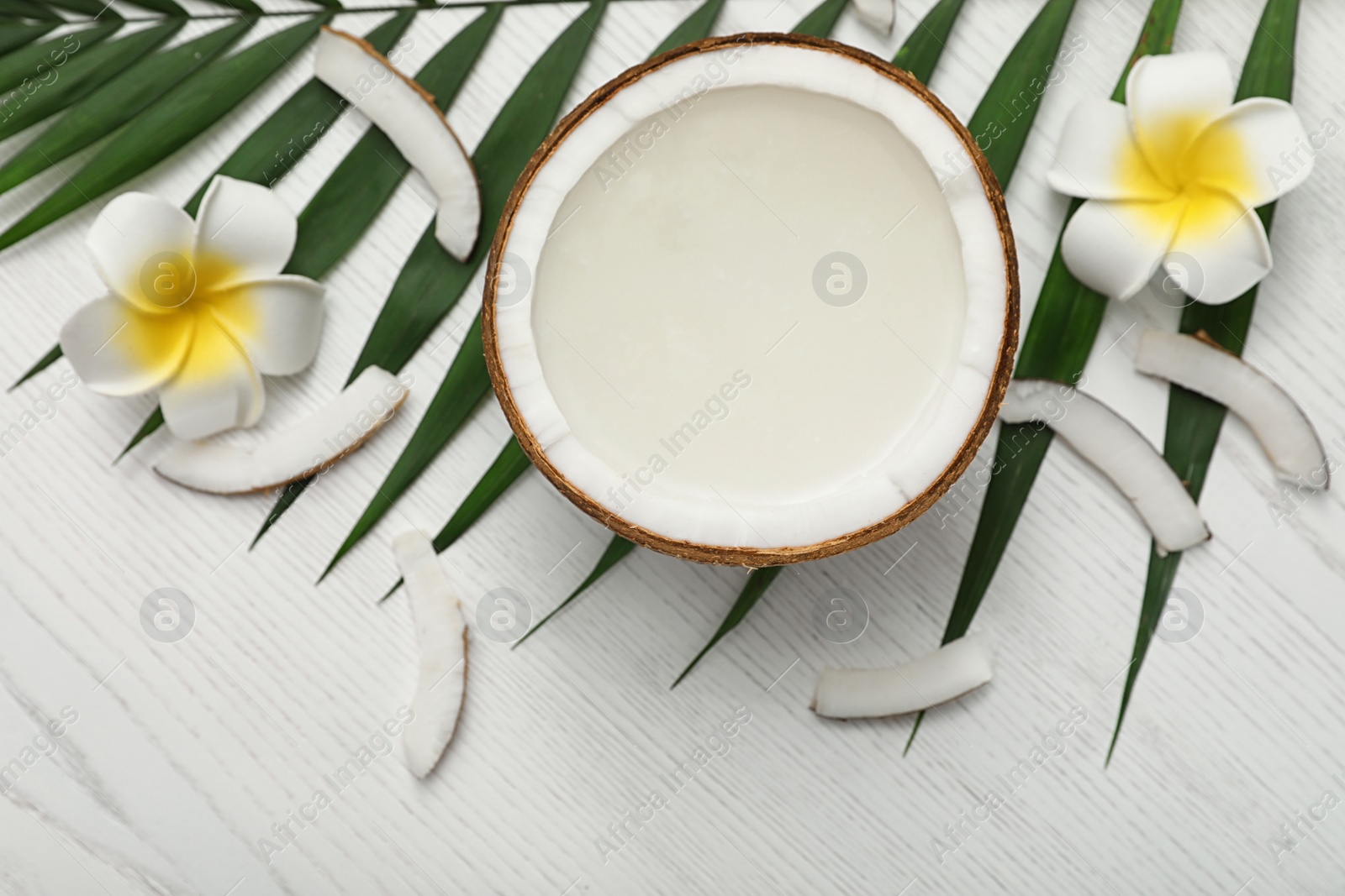 Photo of Composition with half of coconut on white wooden background