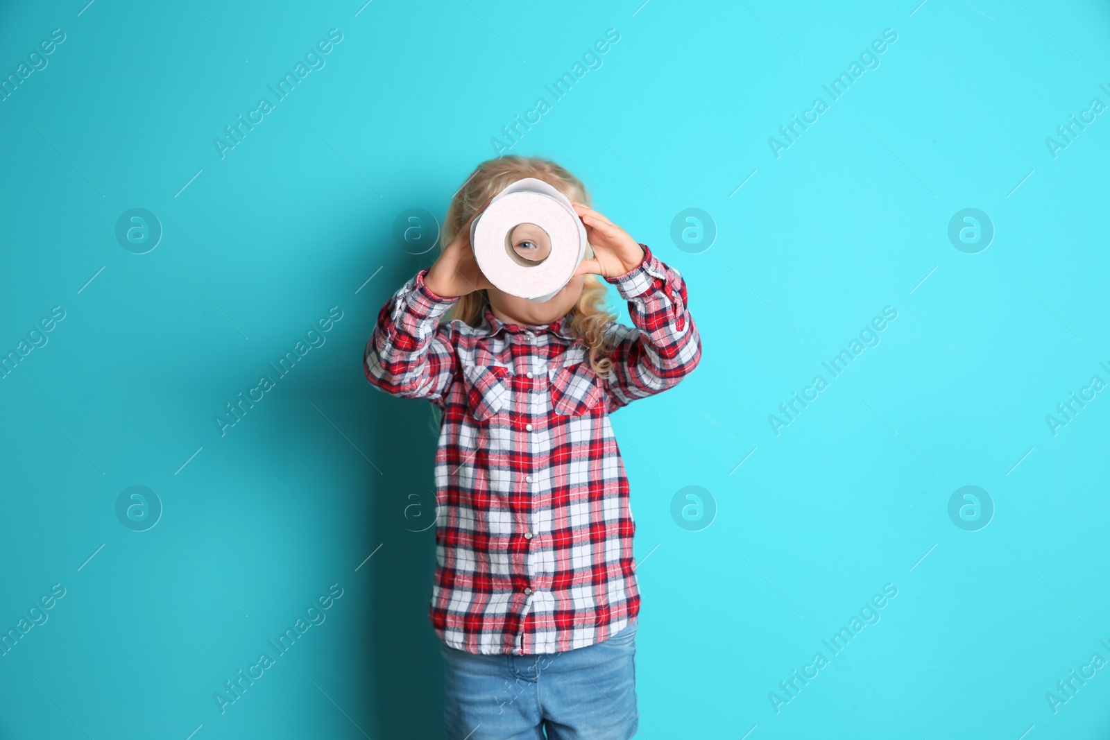 Photo of Cute little girl looking through toilet paper roll on color background