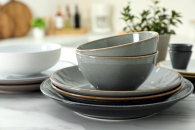 Set of beautiful ceramic tableware on white table in kitchen