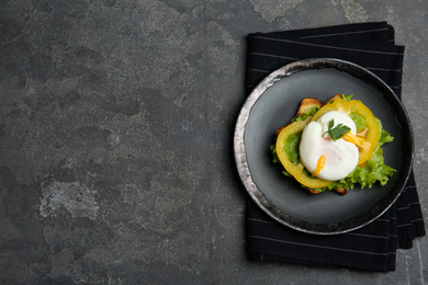 Delicious poached egg sandwich served on grey table, flat lay. Space for text