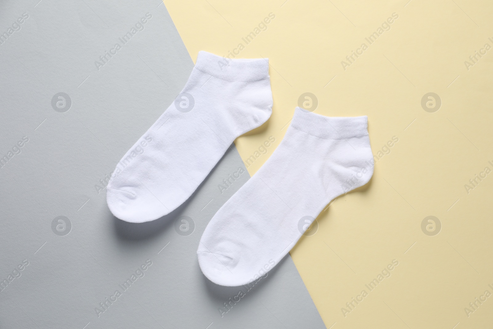 Photo of Pair of white socks on colorful background, flat lay