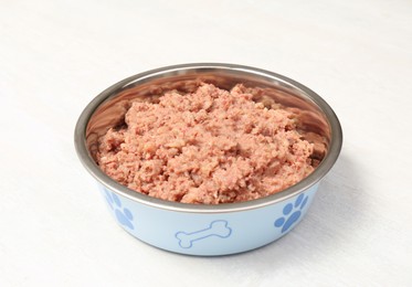 Photo of Wet pet food in feeding bowl on white table