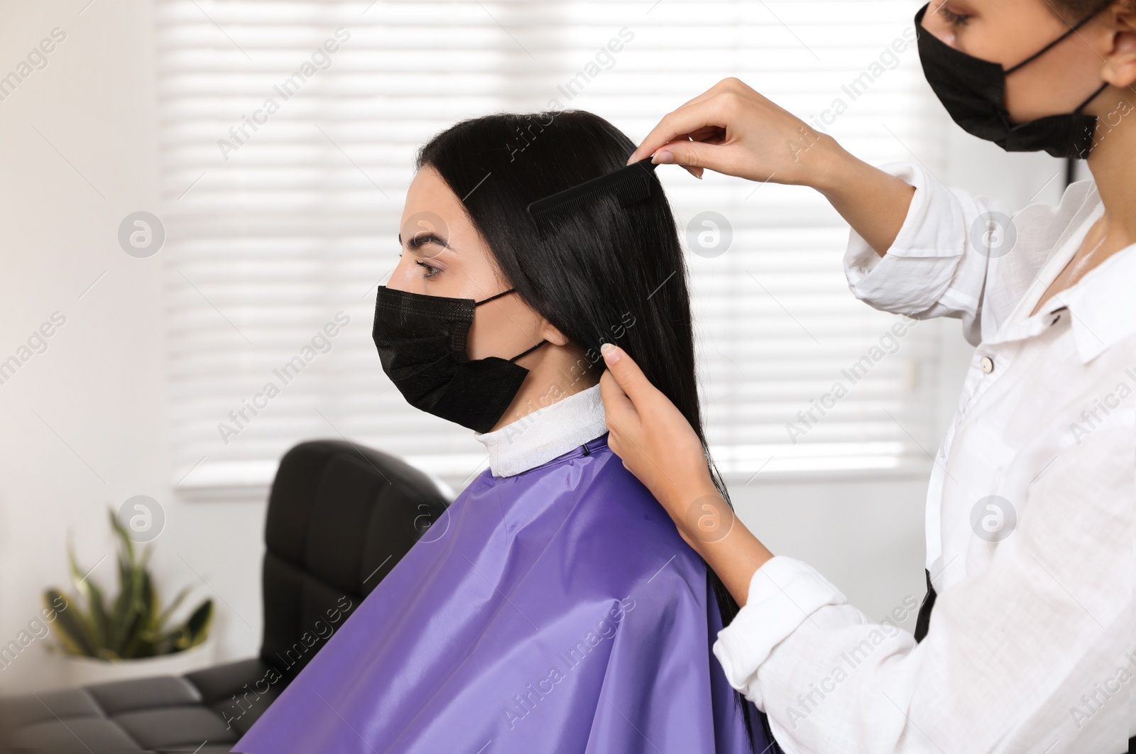 Photo of Professional stylist working with client in salon. Hairdressing services during Coronavirus quarantine