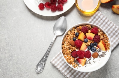 Photo of Healthy homemade granola with yogurt served on grey table, flat lay. Space for text
