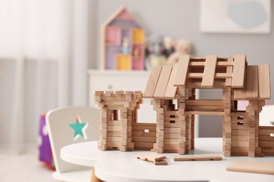 Photo of Wooden entry gate and building blocks on white table indoors, space for text. Children's toy