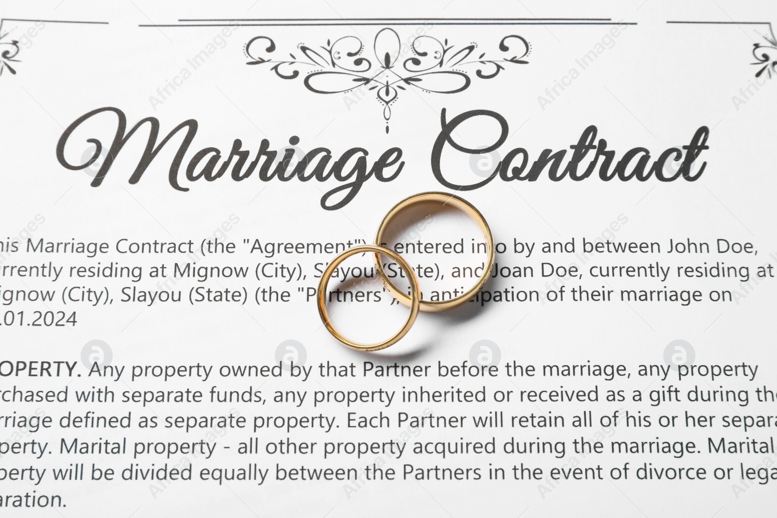 Photo of Marriage contract and gold rings on table, top view