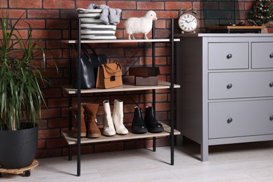 Photo of Beautiful hallway interior with chest of drawers and shoe storage bench near red brick wall