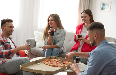 Group of friends with drinks and pizza at home