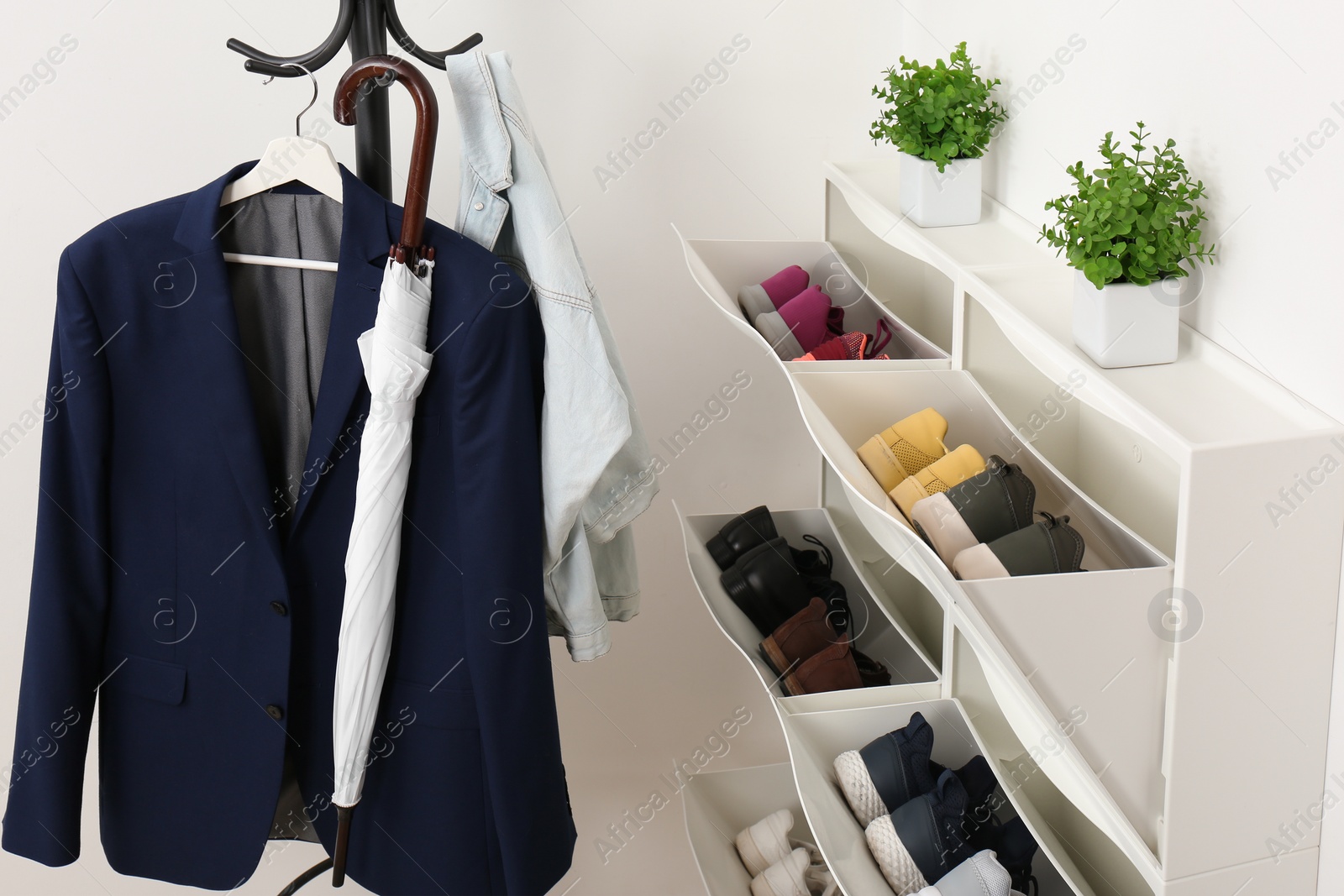 Photo of Shoe cabinet with footwear in room. Storage ideas