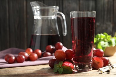 Photo of Delicious grape soda water with mint and berries on wooden table. Refreshing drink