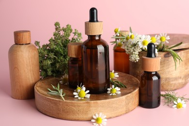 Photo of Aromatherapy. Different essential oils and flowers on pink background