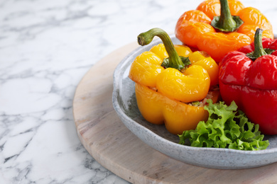 Photo of Tasty stuffed bell peppers on white marble table, closeup