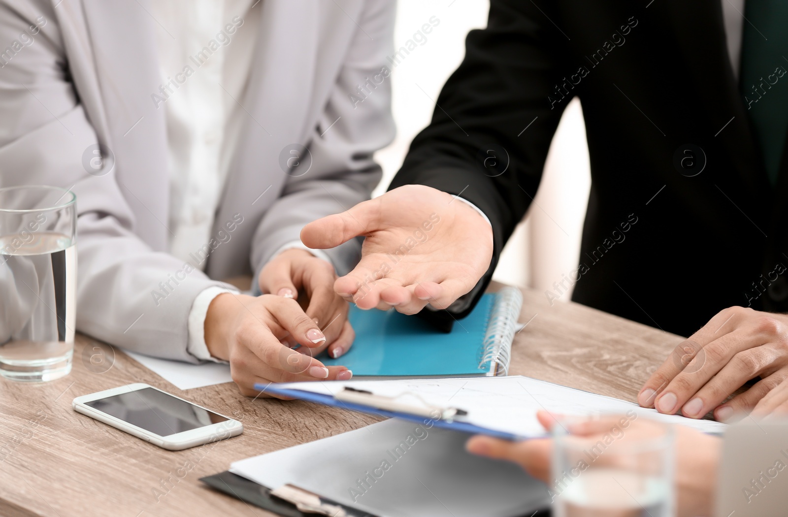 Photo of Young consultant working with clients in office