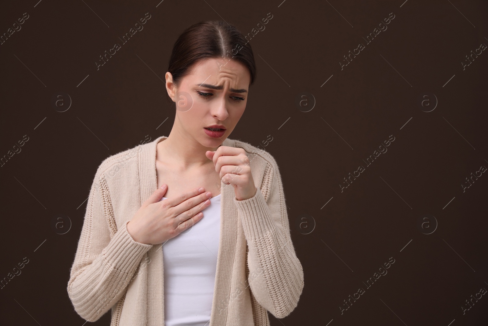 Photo of Woman coughing on brown background, space for text. Cold symptoms