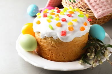 Photo of Beautiful Easter cake and painted eggs on light grey table