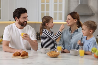 Happy family having breakfast at table in kitchen