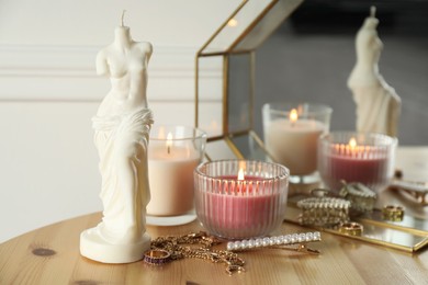 Photo of Beautiful Venus De Milo candle on wooden table. Stylish decor
