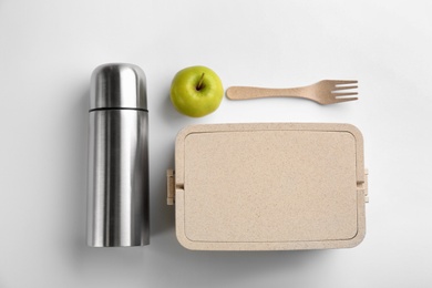 Photo of Thermos, lunch box and apple on white background, top view