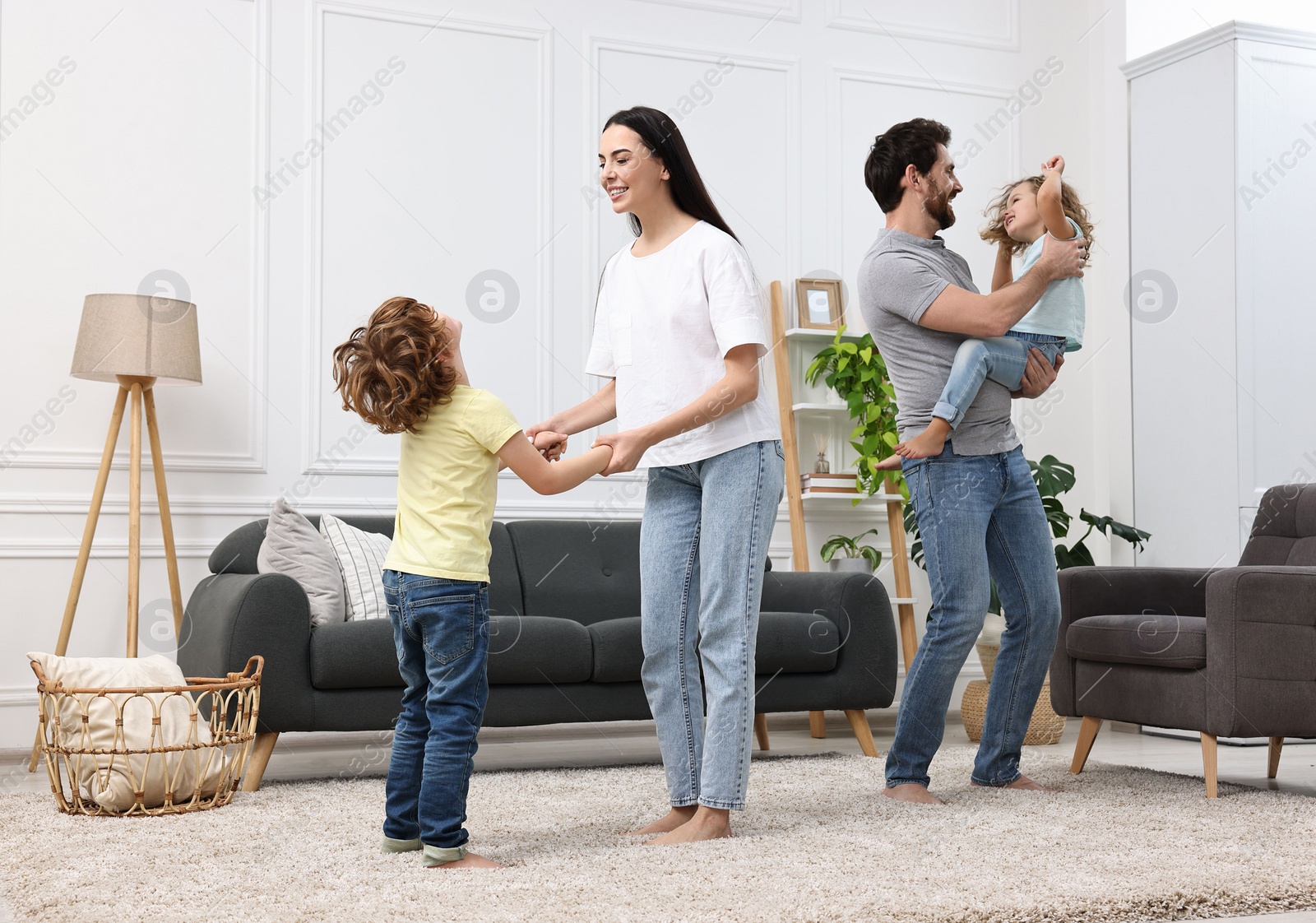 Photo of Happy family dancing and having fun in living room