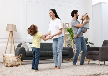 Happy family dancing and having fun in living room