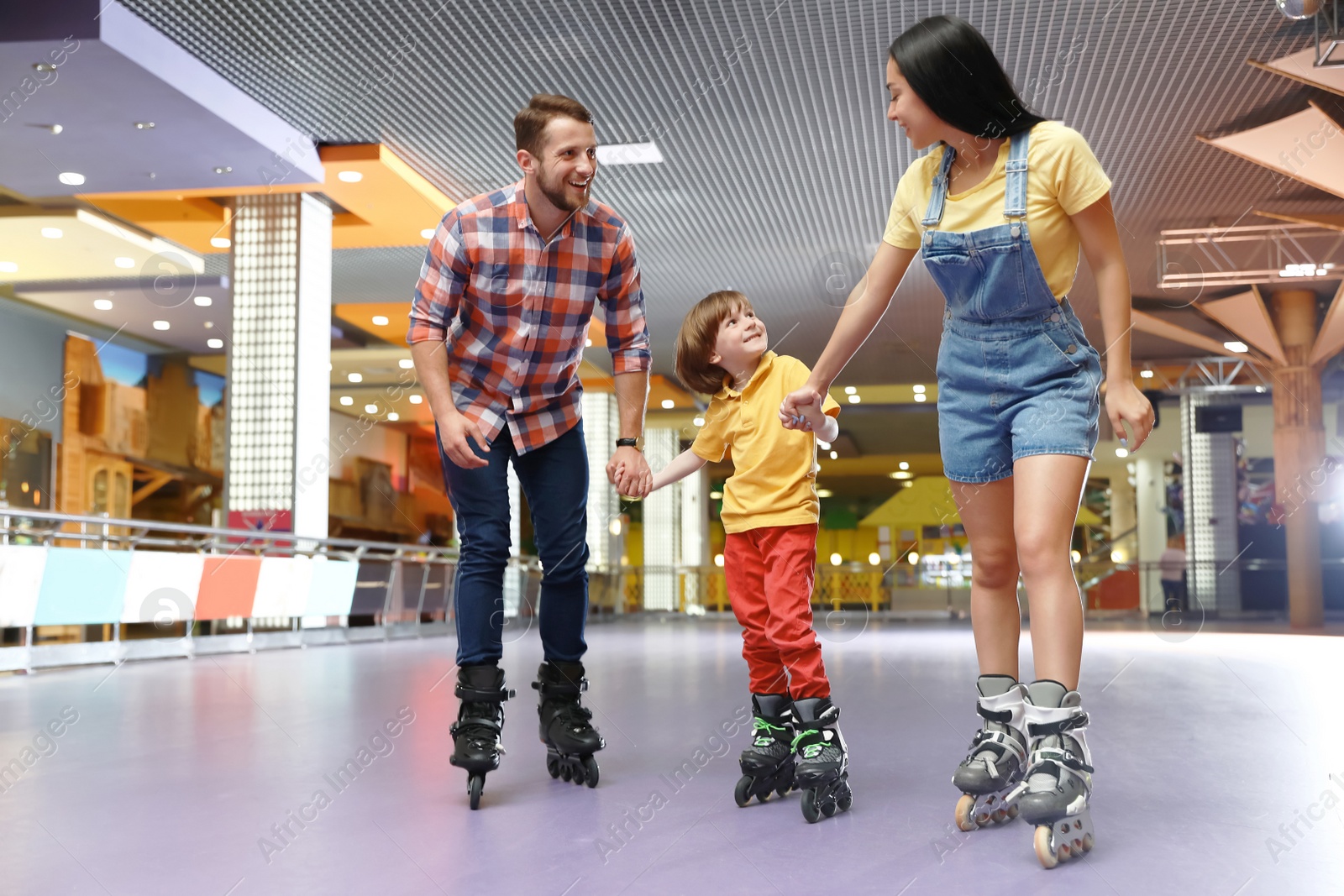 Photo of Happy family spending time at roller skating rink