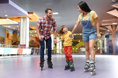 Happy family spending time at roller skating rink