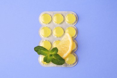 Fresh lemon slice, mint leaves and blister with cough drops on lilac background, flat lay