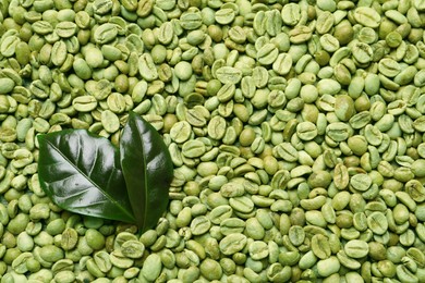 Photo of Many green coffee beans and leaves as background, top view