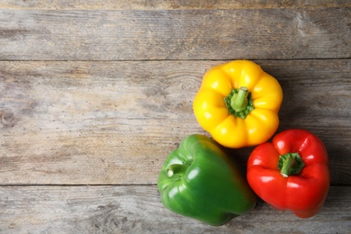 Photo of Raw ripe paprika peppers on wooden background, top view