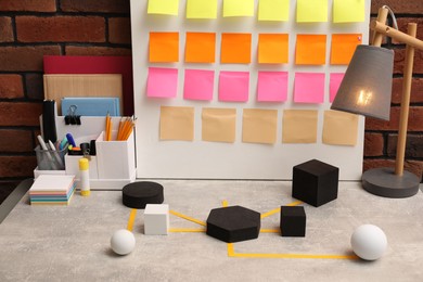 Photo of Business process scheme with geometric figures and stationery on light grey table