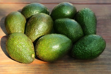 Photo of Many tasty ripe avocados on wooden table