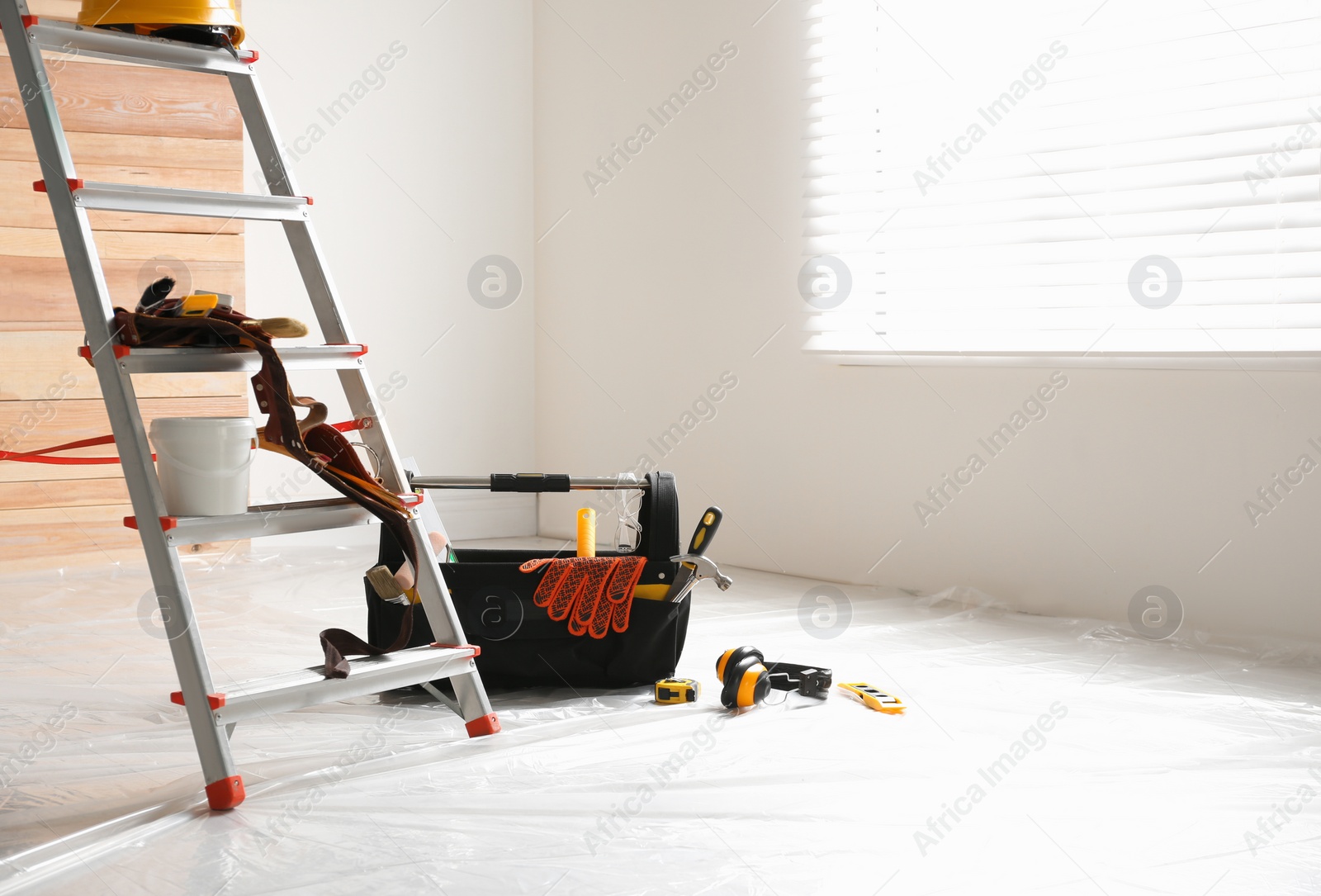 Photo of Stepladder and different tools in room. Interior renovation