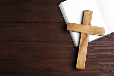 Christian cross and Bible on wooden background, top view with space for text. Religion concept