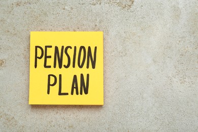 Photo of Paper note with words Pension Plan on light textured table, top view. Space for text
