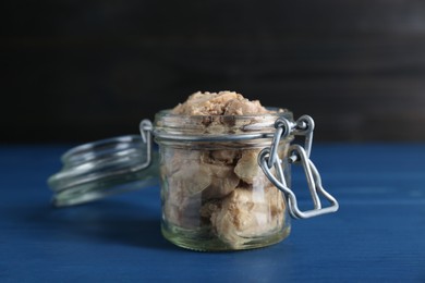 Glass jar of tasty cod liver on blue wooden table