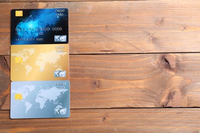 Photo of Many credit cards on wooden table, flat lay. Space for text