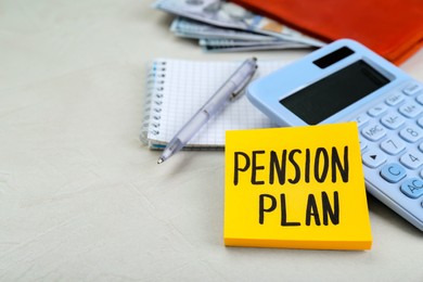 Photo of Note with words Pension Plan, calculator and stationery on white table, closeup. Space for text