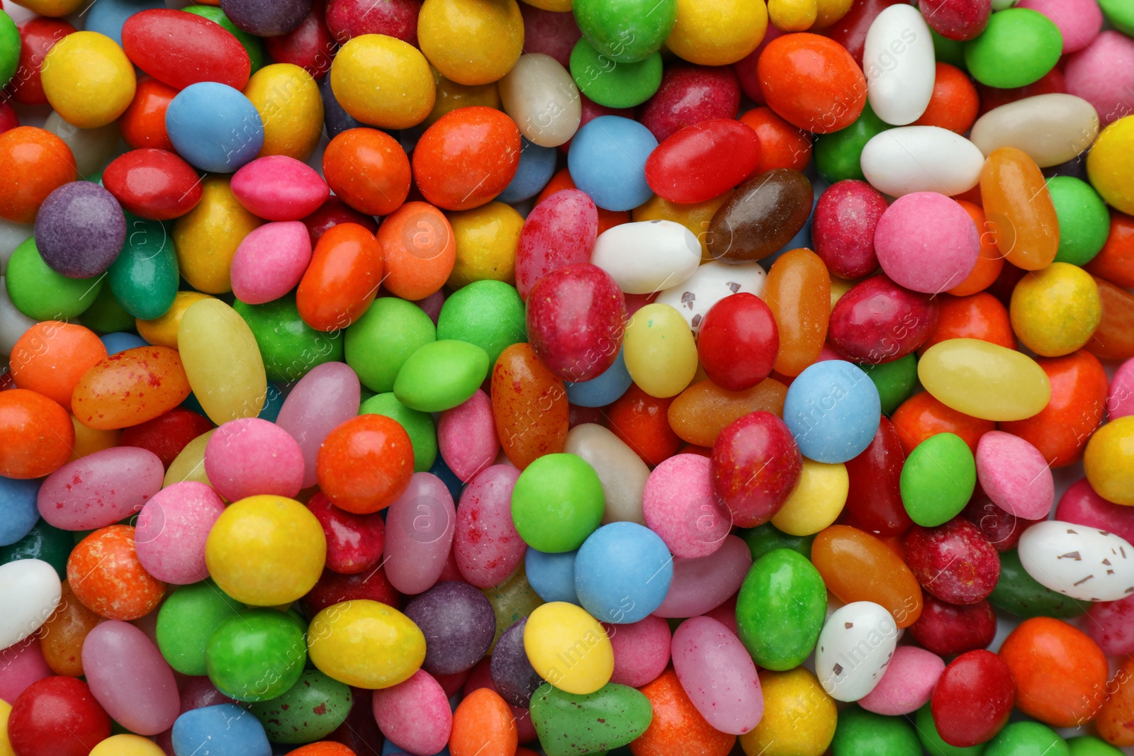 Photo of Many tasty colorful dragee candies as background, top view