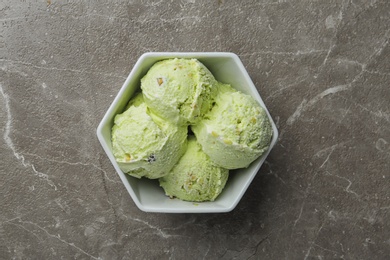 Photo of Delicious pistachio ice cream on grey marble table, top view