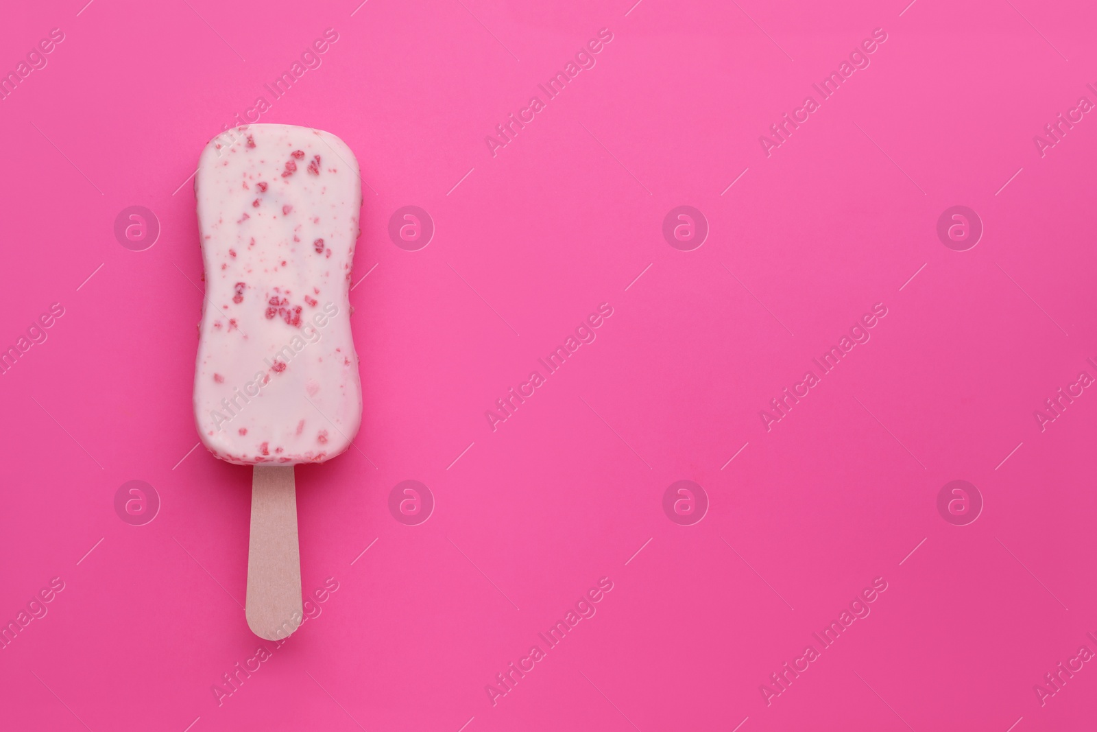 Photo of Delicious glazed ice cream bar on pink background, top view. Space for text