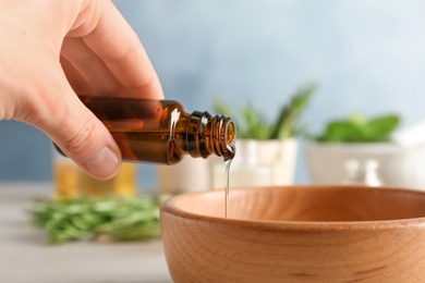 Woman pouring essential oil into bowl