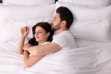 Photo of Lovely couple sleeping together in bed at home, top view