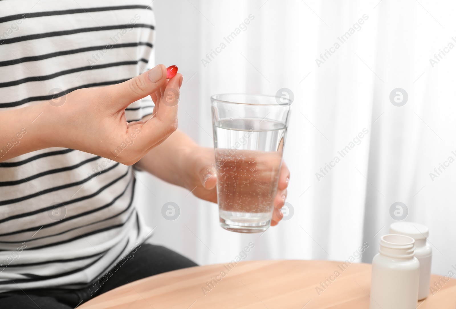 Photo of Young woman taking pill, closeup